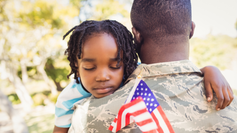 A veteran carrying his son | Black Veterans Need More Access to Mental Health Services | Mindful Health Solutions