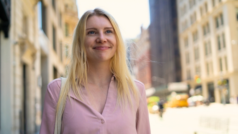 Woman smiling confidently and optimistically on a city street | Psychotherapy for OCD 7 Benefits of Exposure and Response Prevention (ERP)