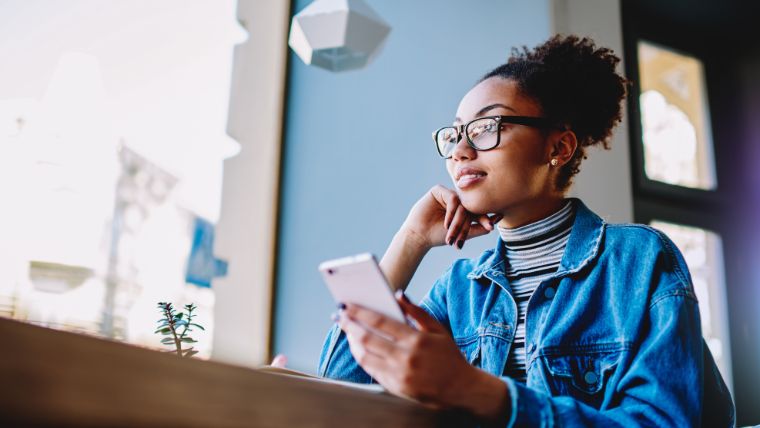 Woman thinking and doing research on her phone | Finding a Therapist or Psychiatrist: How to Make the Best Decision for Your Mental Health