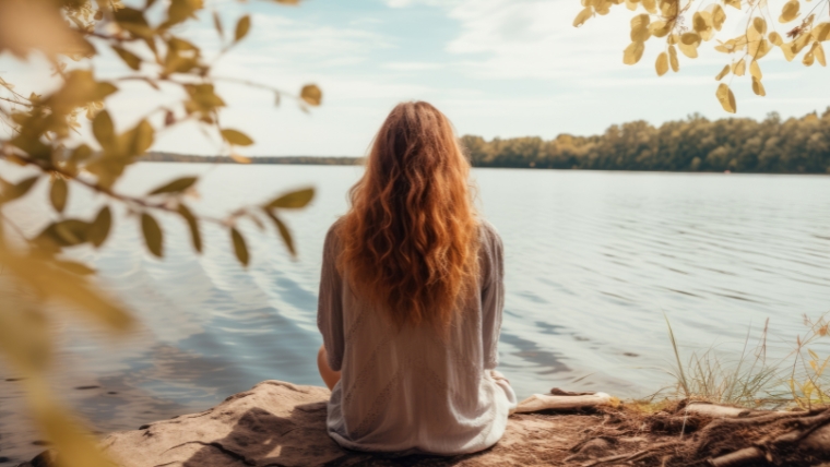 Woman sitting facing a lake | How To Set and Maintain Healthy Boundaries for Your Emotional Well-Being