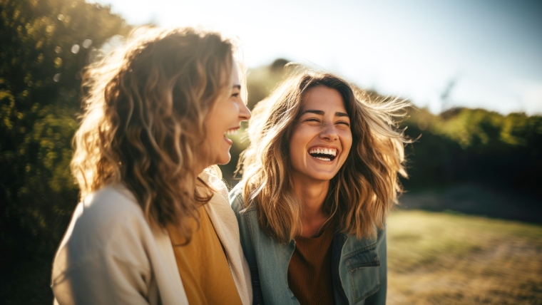 Two women laughing together outside | Feel Better in Just 2 Weeks Accelerated TMS for Major Depression | Mindful Health Solutions