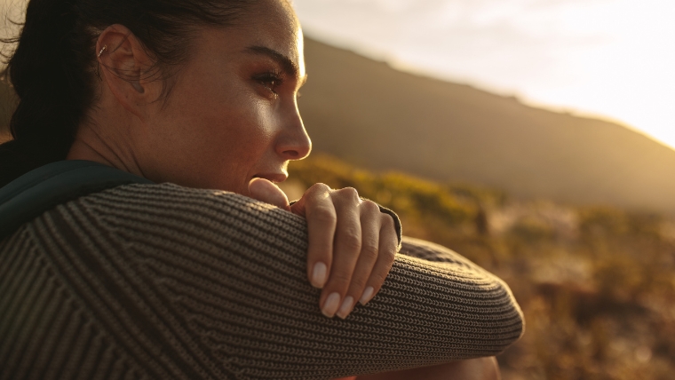 Close-up of a woman sitting outside in the sun thinking and reflecting seriously | Emotional Triggers Why They Matter & How to Manage Them Effectively | Mindful Health Solutions