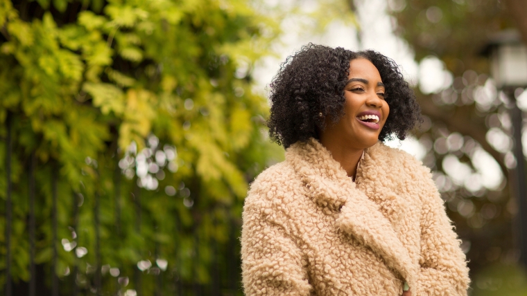 A woman in a coat outside smiling | Need a Confidence Boost 10 Powerful Ways that Will Raise Your Mental Health | Mindful Health Solutions