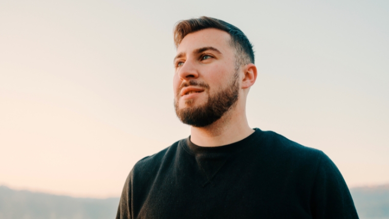 A person standing outside looking up and out toward the horizon with a hopeful expression | Accelerated dTMS The Day-to-Day of this Powerful Depression Treatment | Mindful Health Solutions