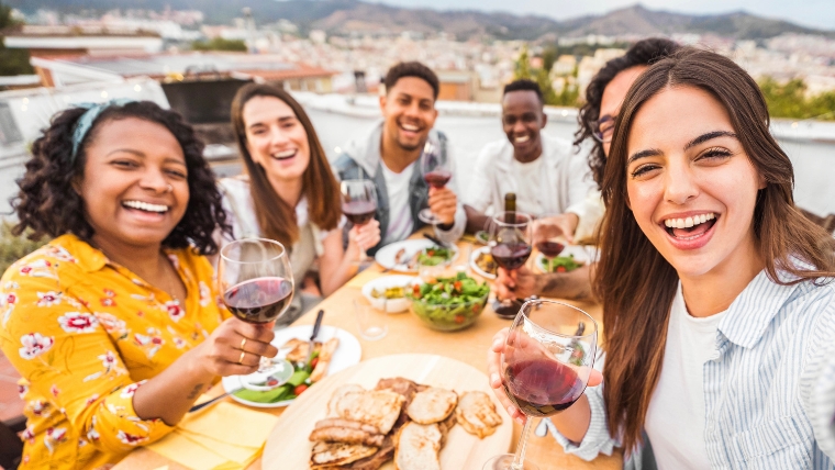 A group of friends at a rooftop dinner party | 10 Ways To Successfully Handle Social Gatherings with Social Anxiety | Mindful Health Solutions