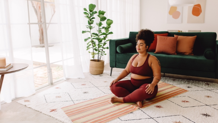 A person peacefully going yoga in their living room | 13 Surprising Ways Body Image Impacts Your Mental Health | Mindful Health Solutions