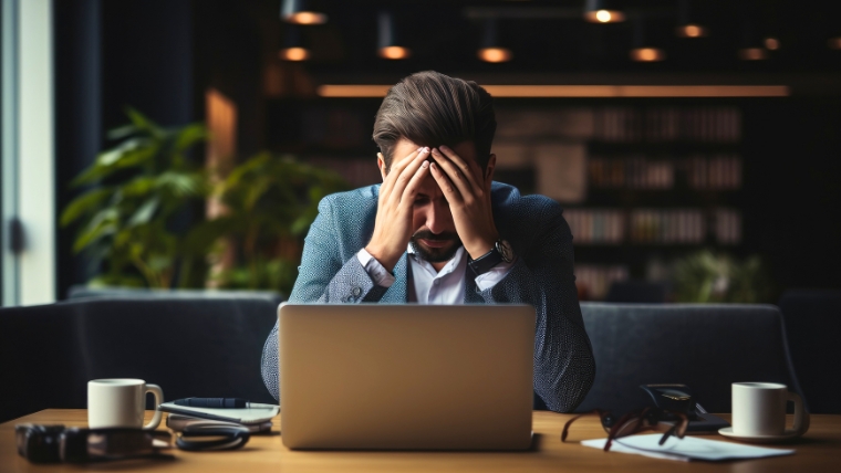 Mentally distressed businessman with his head in his hands at his desk | Mental Health Leave 10 Practical Tips for Discussing with Your Boss