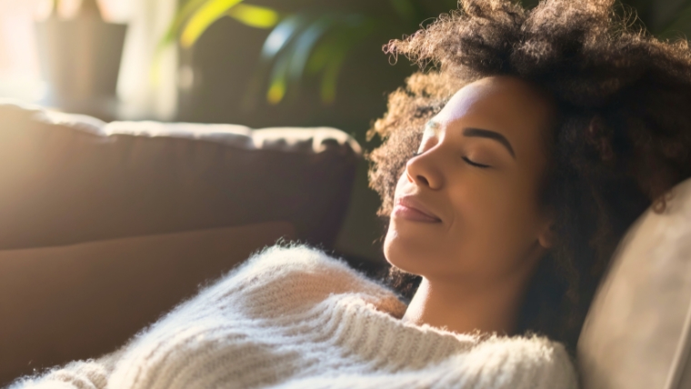 Woman laying on her couch, at peace, taking a deep breath, slightly smiling | 24 Ways to Transform Negative Thoughts with Cognitive Behavioral Techniques