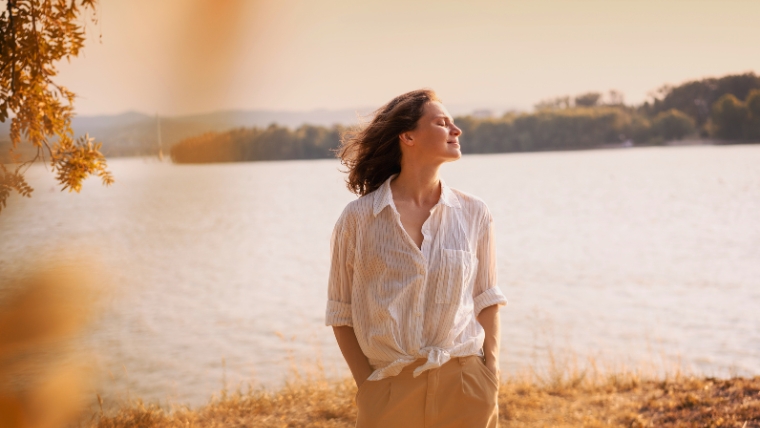 Woman standing outside and being present with eyes closed and hands in pockets | 8 Practical Tips To Improve Your Self-Image | Mindful Health Solutions