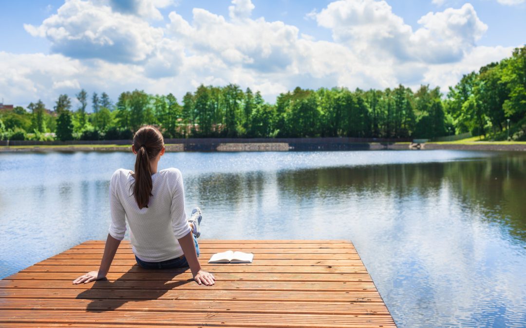 Woman peacefully sitting on dock in preparation for IV ketamine therapy